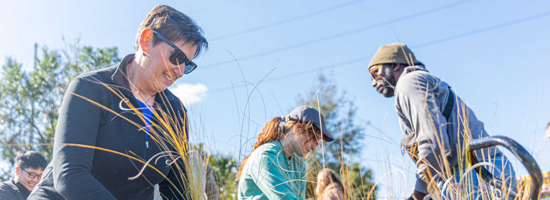 Three people planting at a service event.